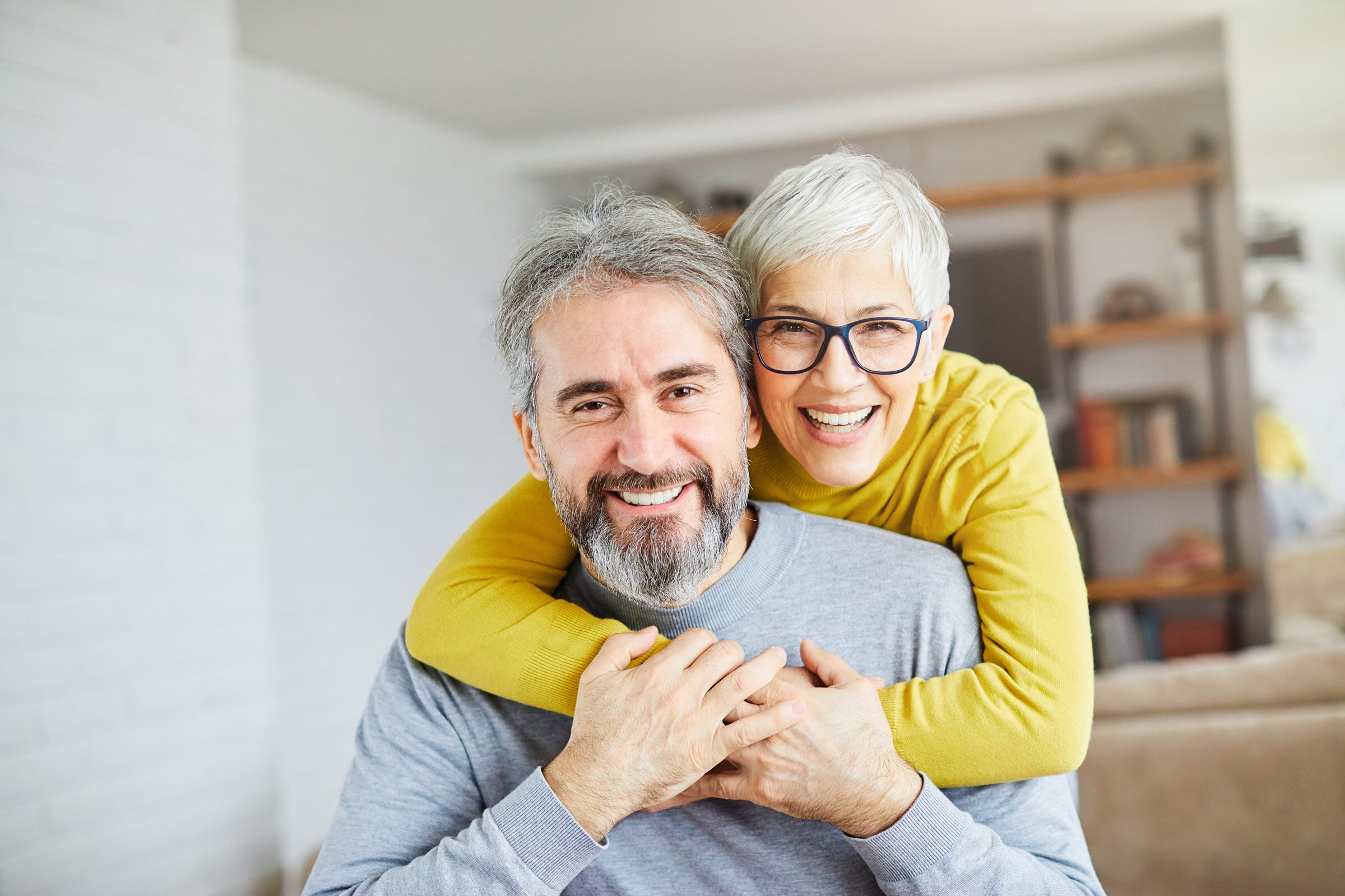 Smiling couple embracing at home